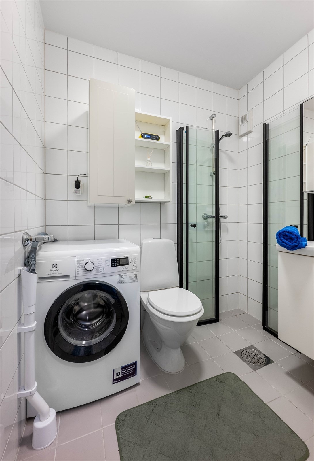 Badet inneholder dusjhjørne, servant, frittstående toalett og opplegg for vaskemaskin. Mekanisk avtrekk sikrer god ventilasjon i baderommet. Galleribilde