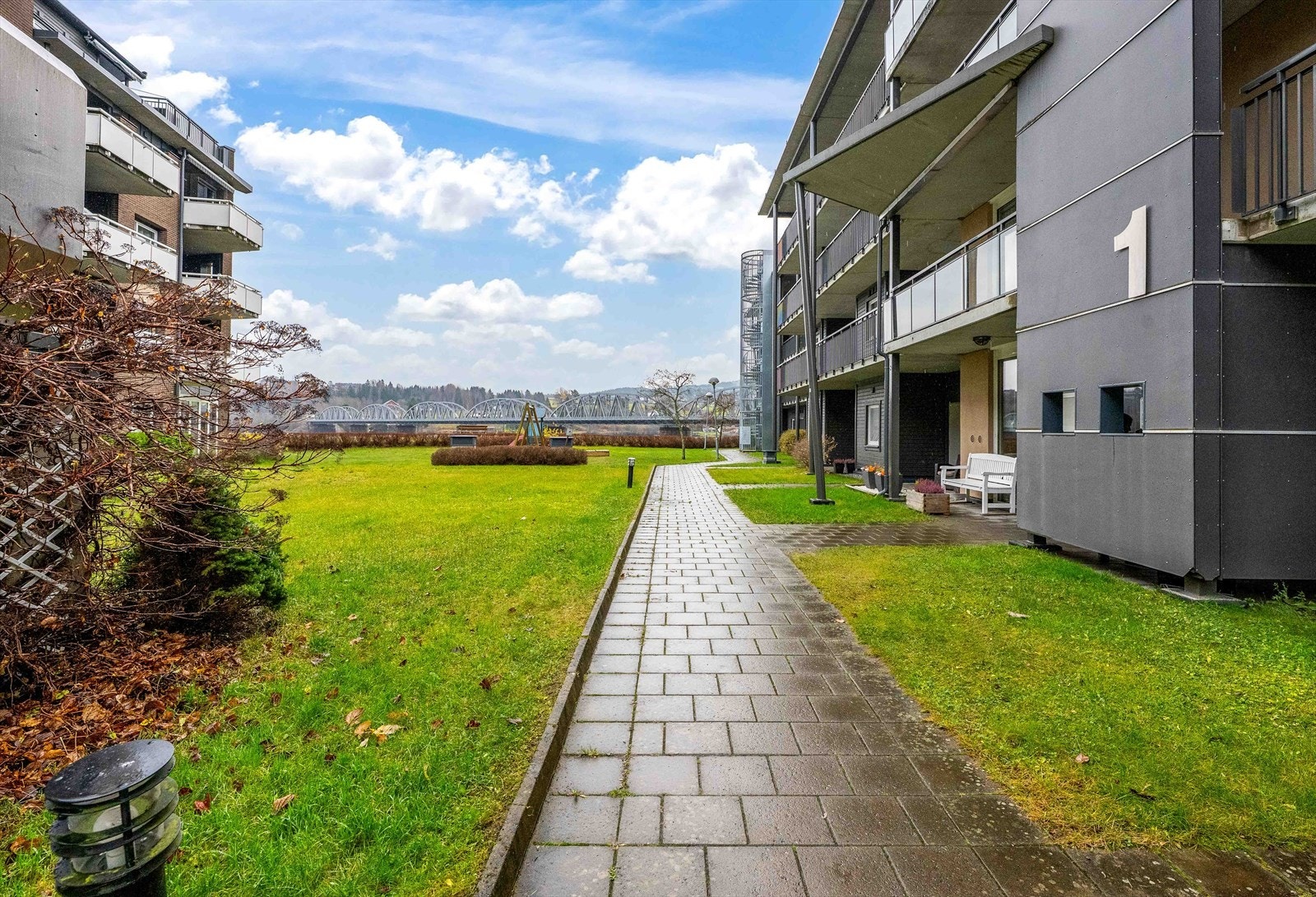 Adkomst til leiligheten via gangsti som fører til felles inngangspartiet. Galleribilde