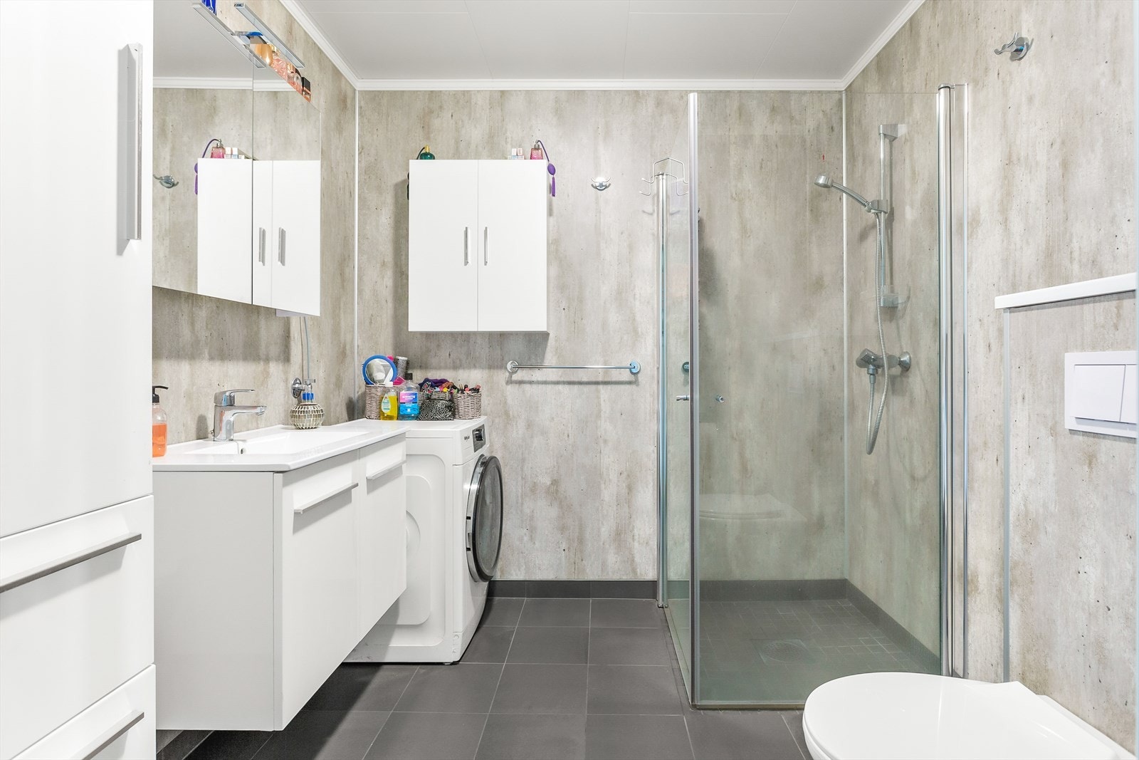 Pent bad med flislagt gulv med gulvvarme og stilige våtromsplater på vegger. Galleribilde