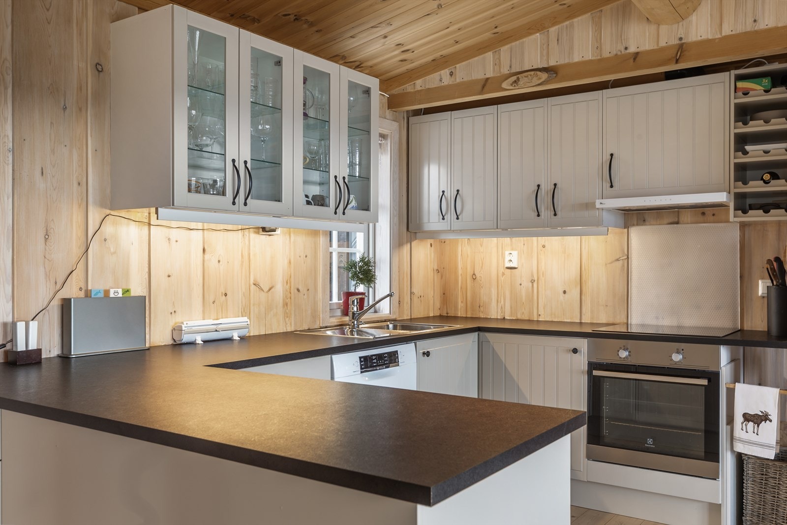 Integrerte hvitevarer med komfyr, koketopp, kjøleskap og ventilator, samt frittstående oppvaskmaskin. Galleribilde