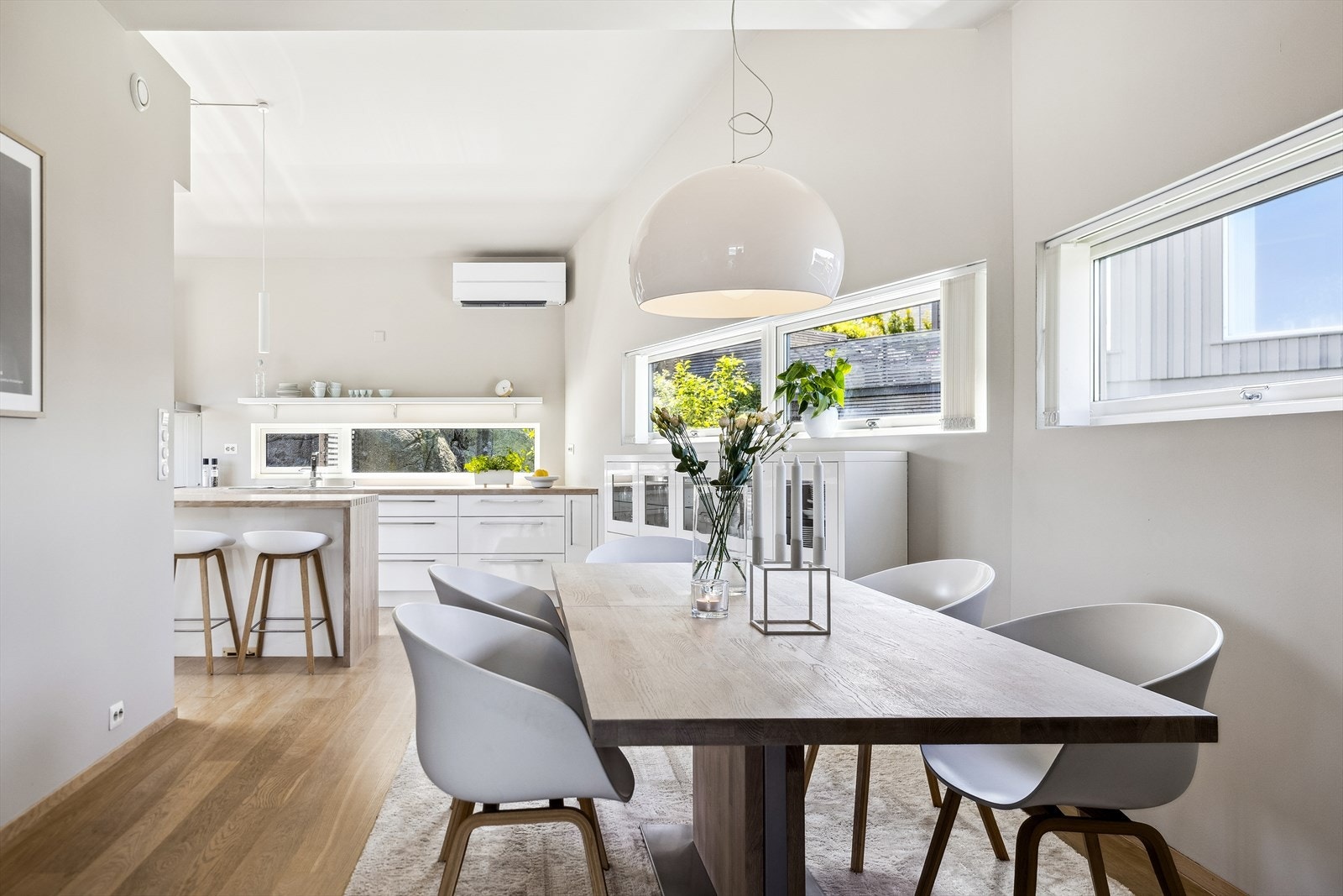 Kjøkken med åpen planløsning mot spisestue. Avlange vinduer gir rikelig med naturlig lys inn og skaper en innbydende atmosfære. Galleribilde