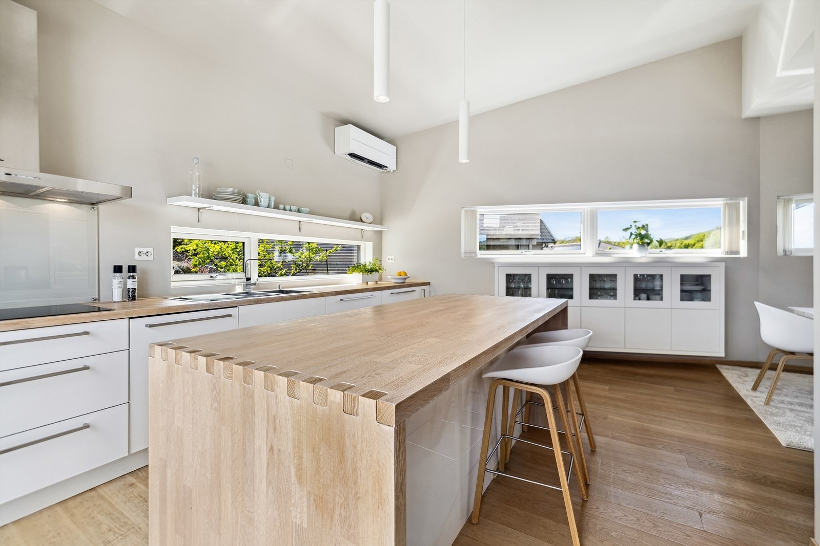 Delikat kjøkken med god benkeplass og stilrene detaljer. Varmepumpe på vegg. Galleribilde