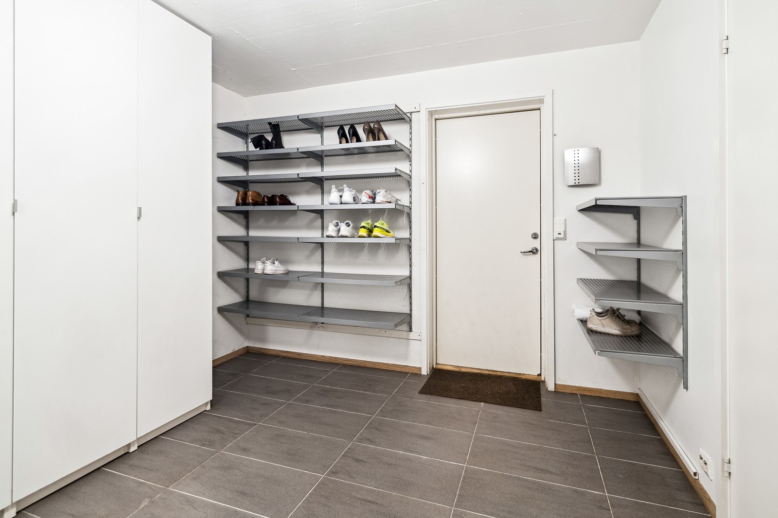 Praktisk biinngang fra garasjen med smarte oppbevaringsløsninger - perfekt for en organisert hverdag med plass til sko, yttertøy og alt du trenger lett tilgjengelig. Galleribilde