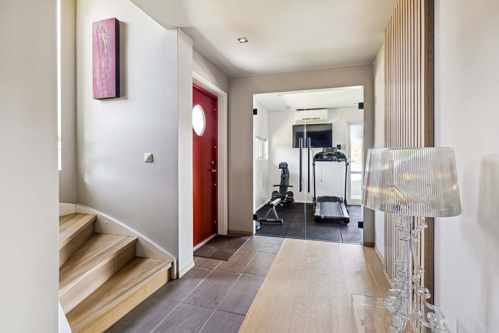 Moderne entré med lys og luftig atmosfære, som leder til treningsrom/tv-stue. En bolig med elegant design med stilfulle detaljer og god planløsning. Galleribilde