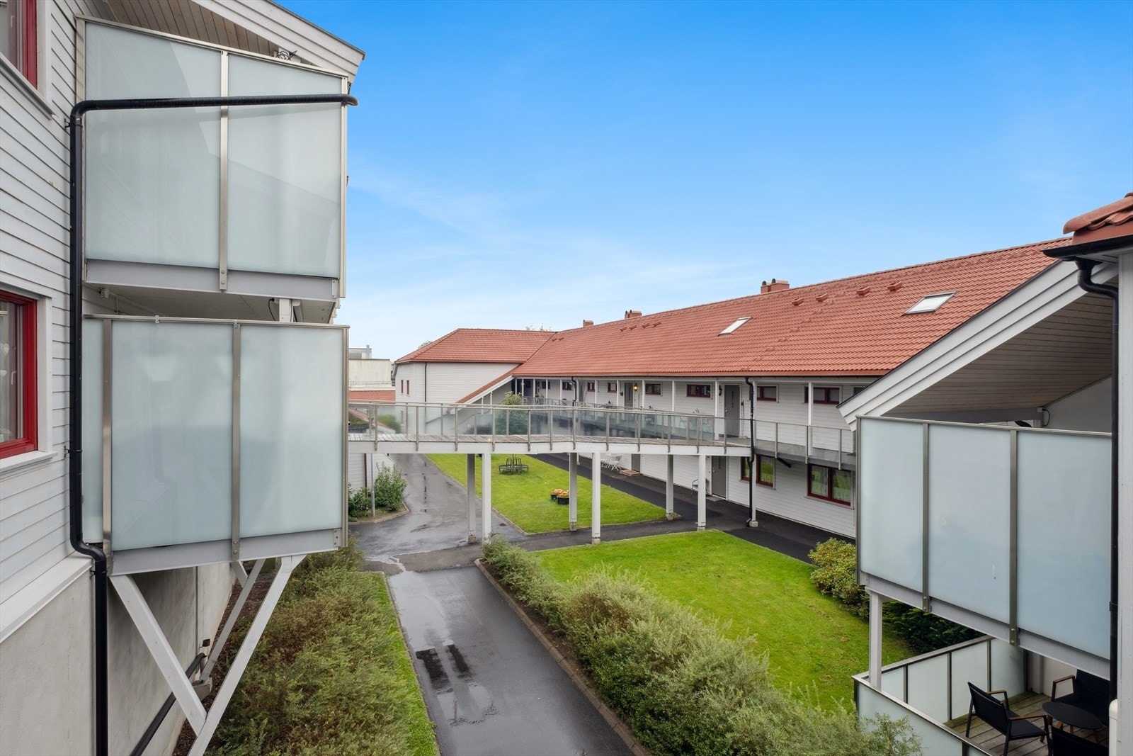 Fra balkongen er det hyggelig utsyn over borettslagets fellestomt som er er reasfaltert og oppgradert i 2023. Galleribilde