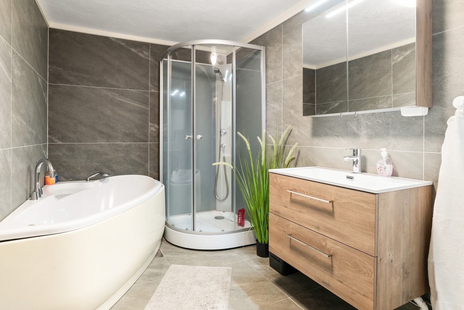 Boligens andre bad er i underetasjen. Badet har flislagt gulv med varmekabler, flislagte vegger og malt murpuss i himling. Galleribilde