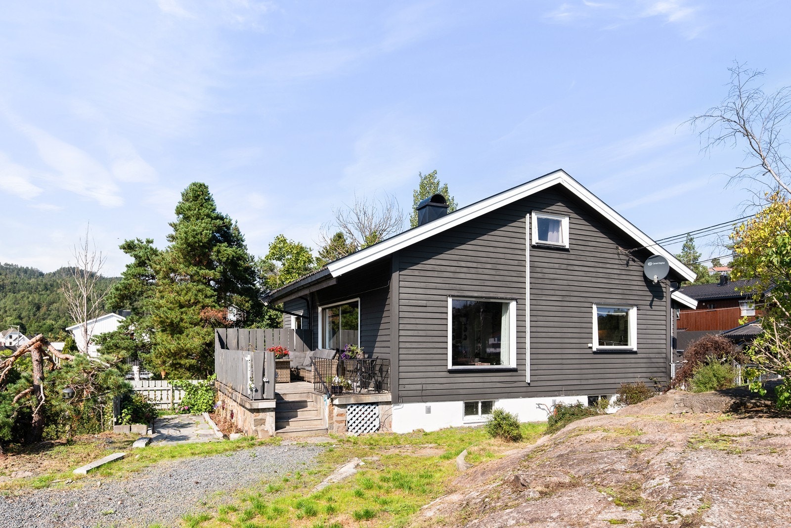 Tomten er opparbeidet med plen, busker og trær. Innkjørselen er dekket med singel og det er flere støttemurer, samt endel synlig fjell. Galleribilde