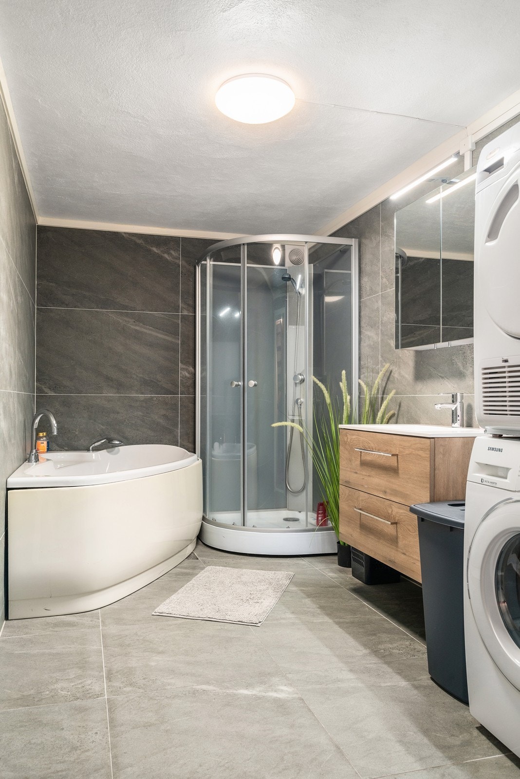 Rommet er innredet med servantskap med nedfelt servant, speilskap med belysning, dusjkabinett og hjørnebadekar. Det er opplegg for vaskemaskin og tørketrommel. Galleribilde