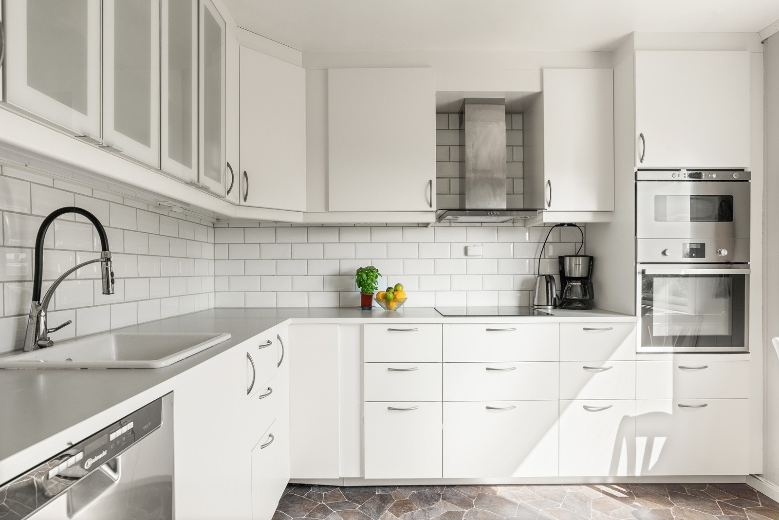 Kjøkkeninnredning fra IKEA med hvite glatte fronter, bestående av både over- og underskap, samt lys under overskap. Kjøkkenet er fra 2016. Galleribilde