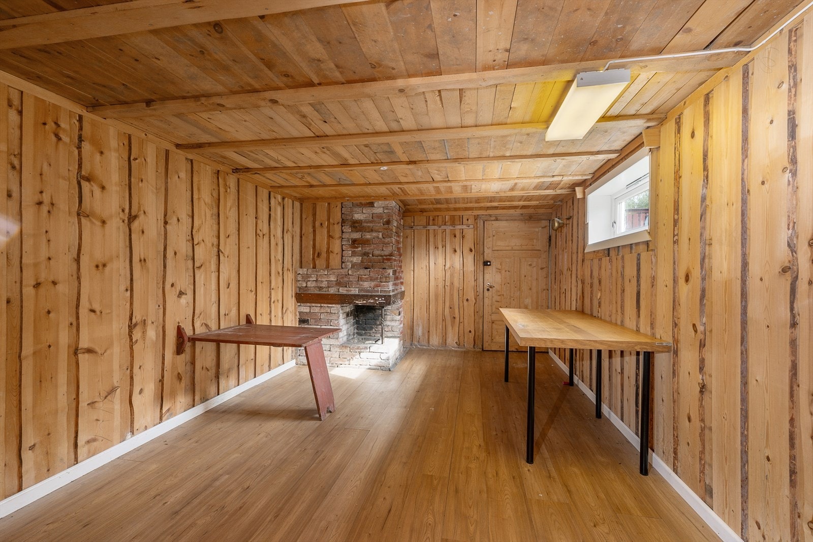 Del av kjeller, innredet som kjellerstue med åpen peis Galleribilde