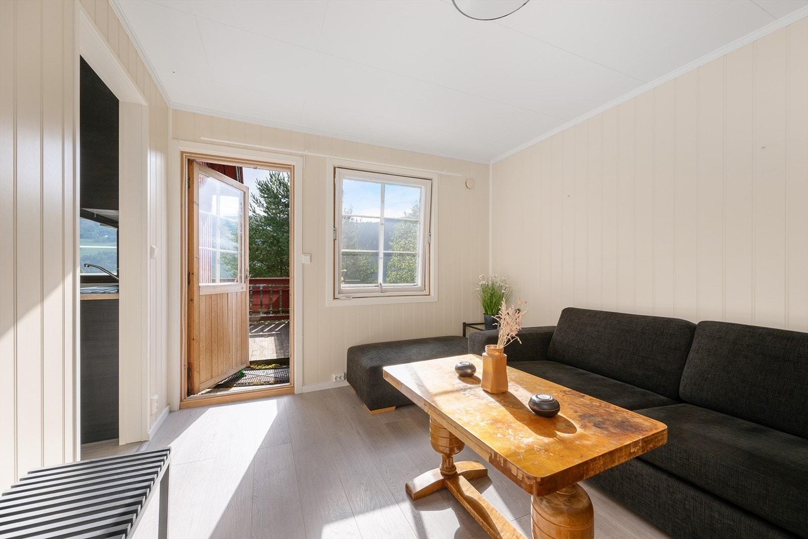 Stue i leiligheten har adkomst til en større terrasse Galleribilde