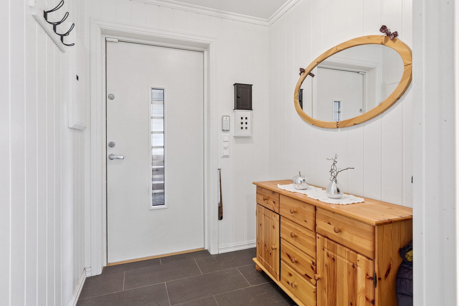 Velkommen inn i en lys og praktisk entré med plass til oppbevaring av yttertøy. Galleribilde