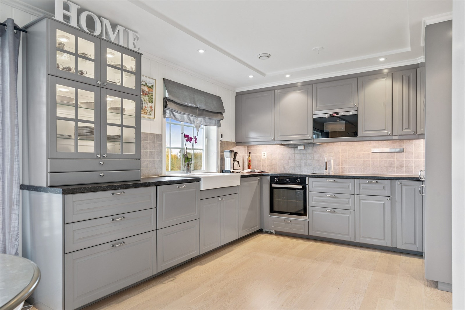 Kjøkkeninnredningen har profilerte fronter og et vitrineskap som gir et klassisk preg. Galleribilde