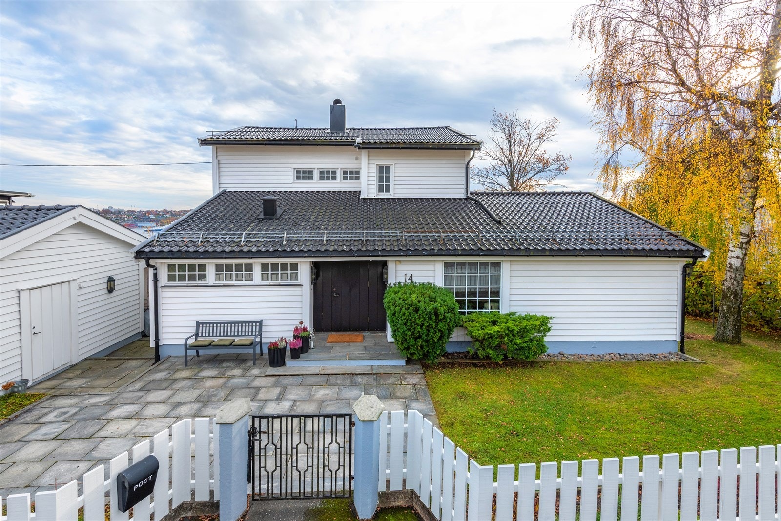 Boligen er klassisk og velholdt med et gjennomført uttrykk. Den hvitmalte fasaden, mørke takstein og innrammingen gir et innbydende førsteinntrykk. Galleribilde