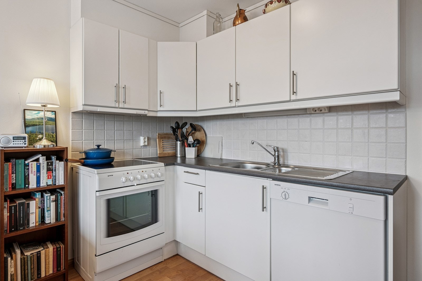 Kjøkkeninnredning med over-og underskap, og oppvaskkum nedfelt i laminat benkeplate. Galleribilde