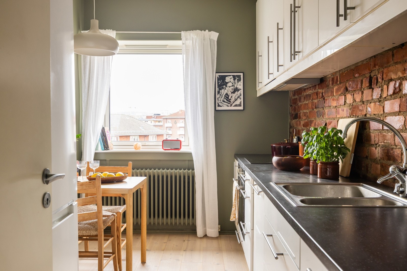 Separat kjøkken malt i trendy fargetone, med innslag av teglstein over benkeplate. Galleribilde