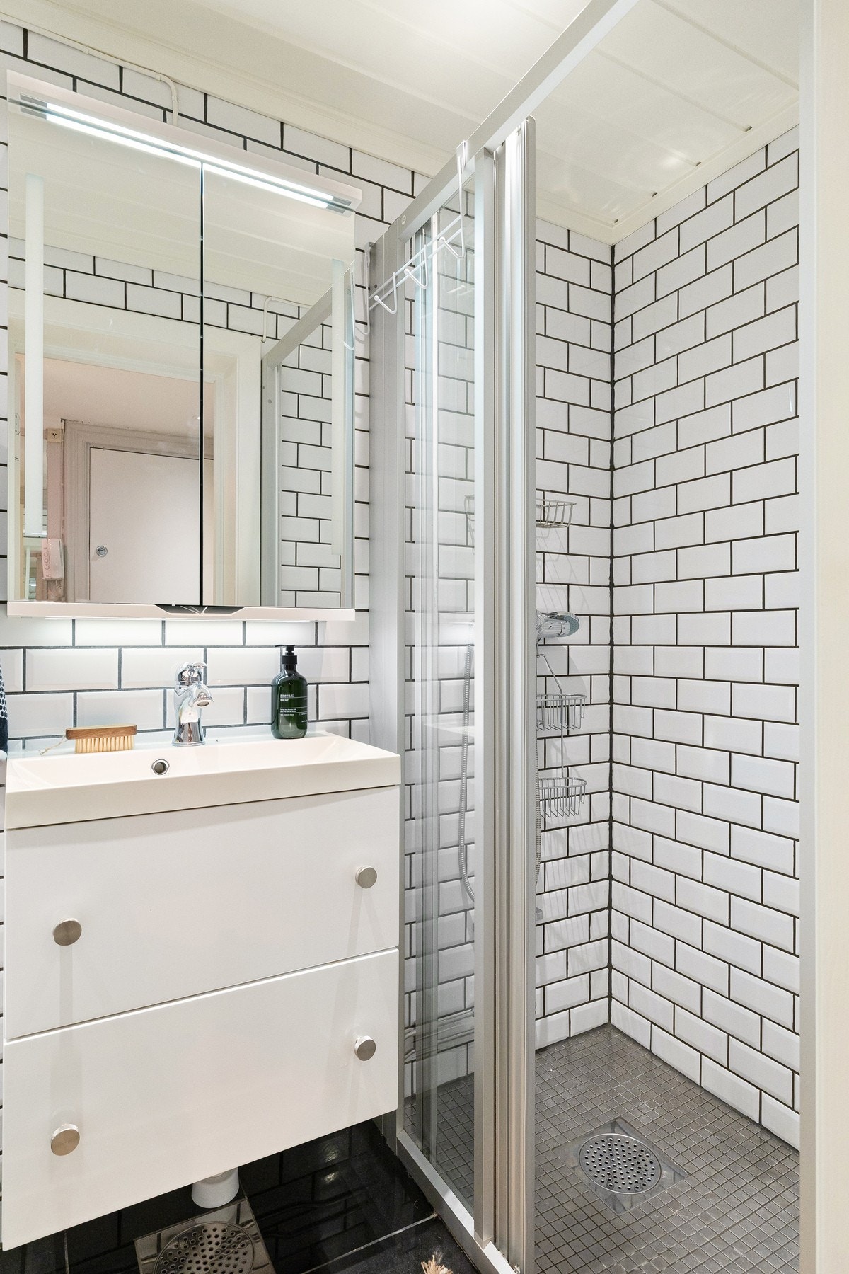 Badet er innredet med servantskap med nedfelt servant, speilskap, gulvmontert toalett og dusjnisje. Galleribilde