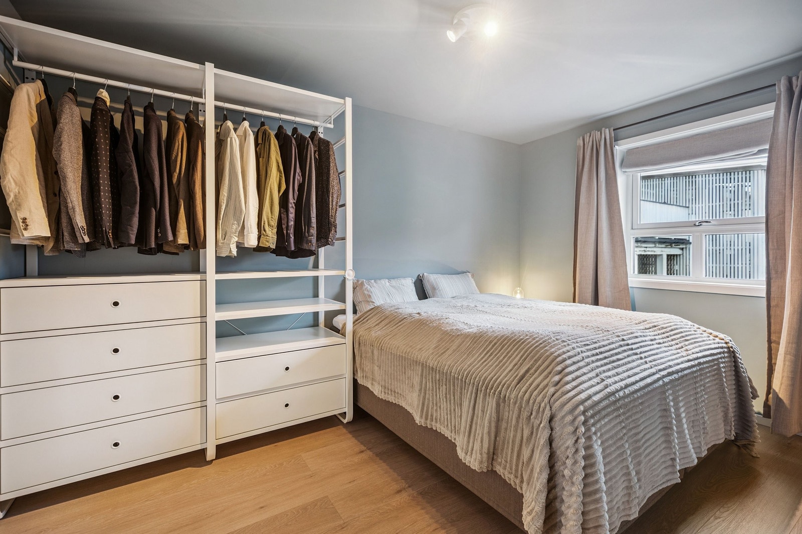 Hovedsoverom med åpent garderobeskap og delikat, nøytral fargepalett - perfekt for avslapning Galleribilde