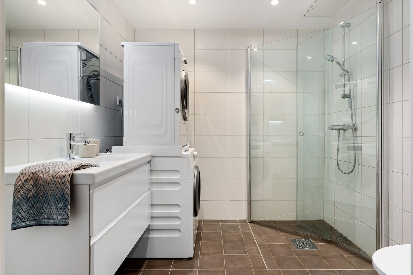 Badet er utstyrt med stilfull innredning fra INR, dusjhjørne, servant, vegghengt toalett og downlights i taket. Galleribilde