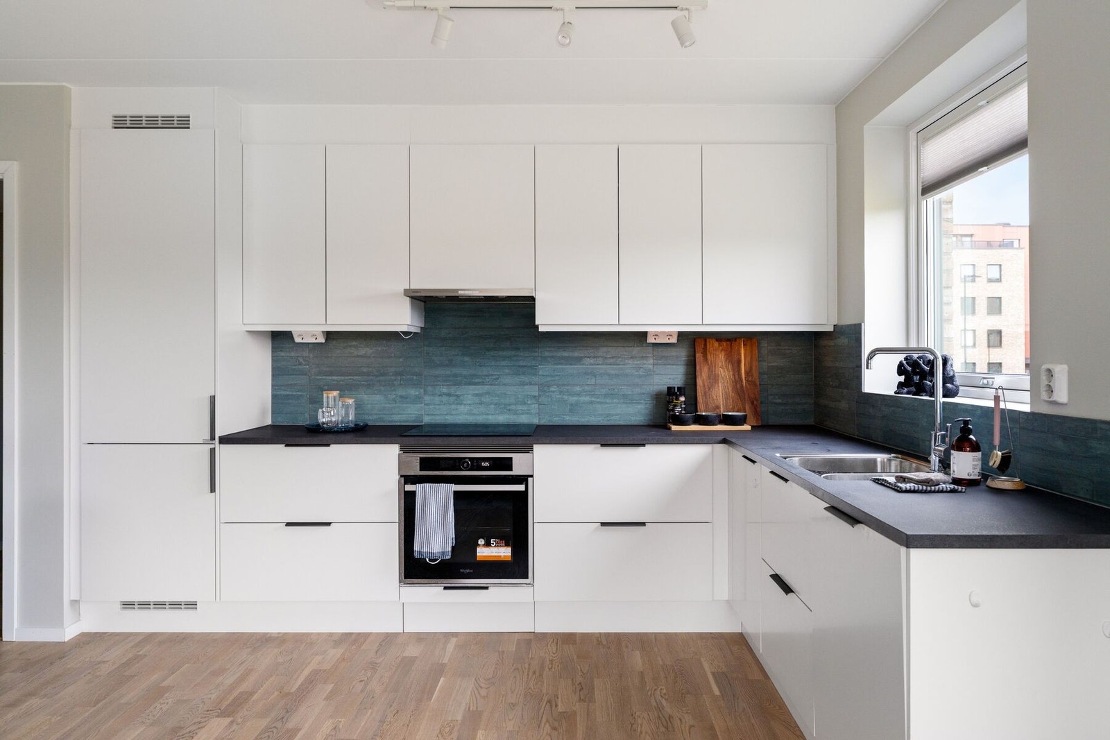 Kjøkkenet byr på integrert induksjonstopp, stekeovn, volumhette, kombi-kjøleskap og oppvaskmaskin. Galleribilde