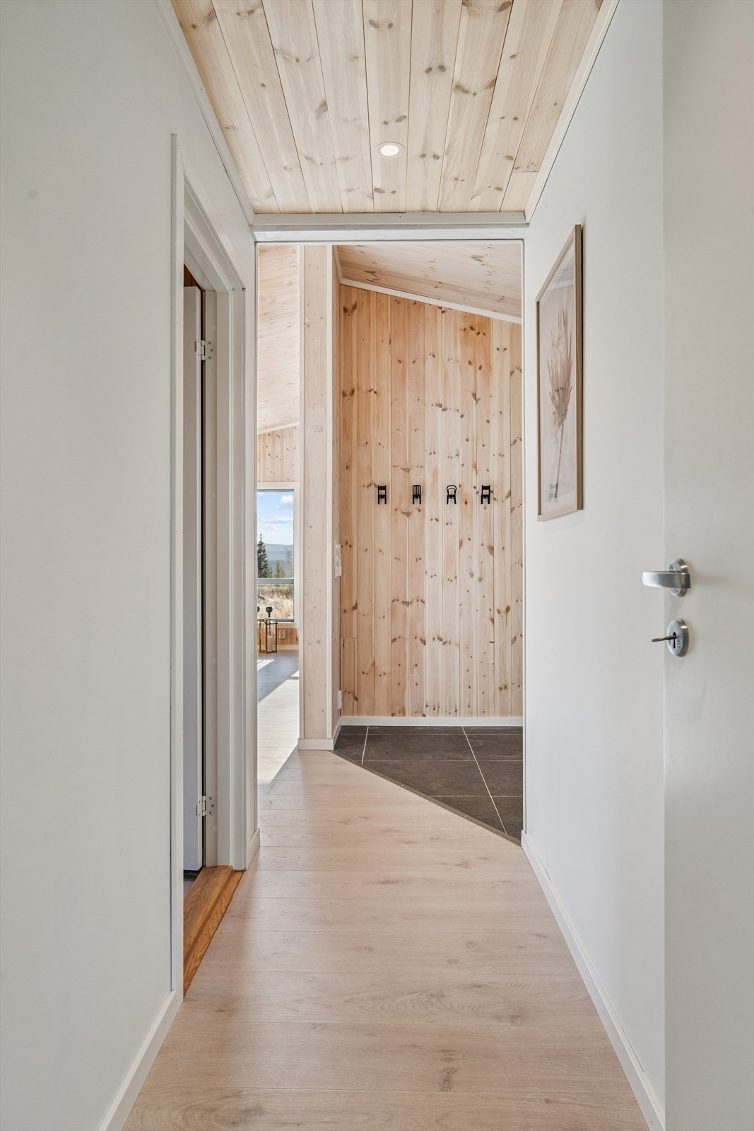 Kombinasjonen av malte plater og trepanel gir en varm innvendig stil. Galleribilde