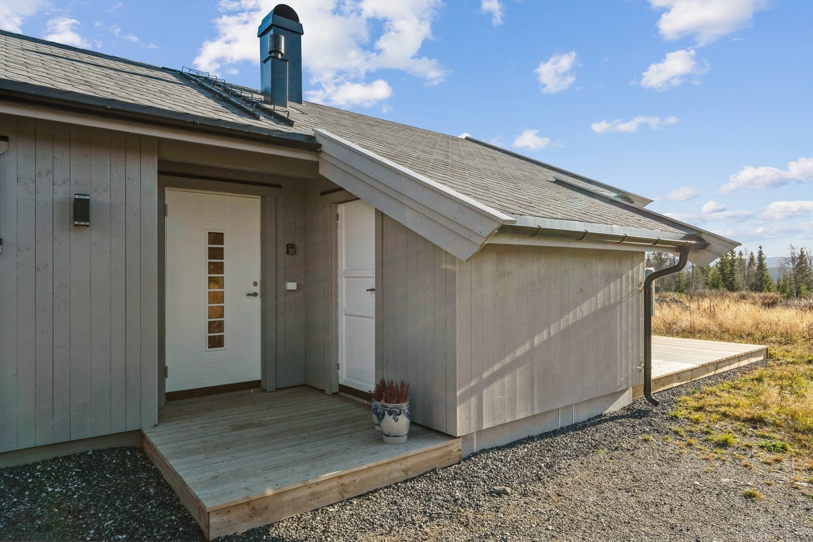 En liten platting foran inngangsdøra ønsker deg velkommen. En romslig utebod ved inngangsdøra er praktisk for å lagre fritidsutstyr, utemøbler eller tørr ved. Galleribilde