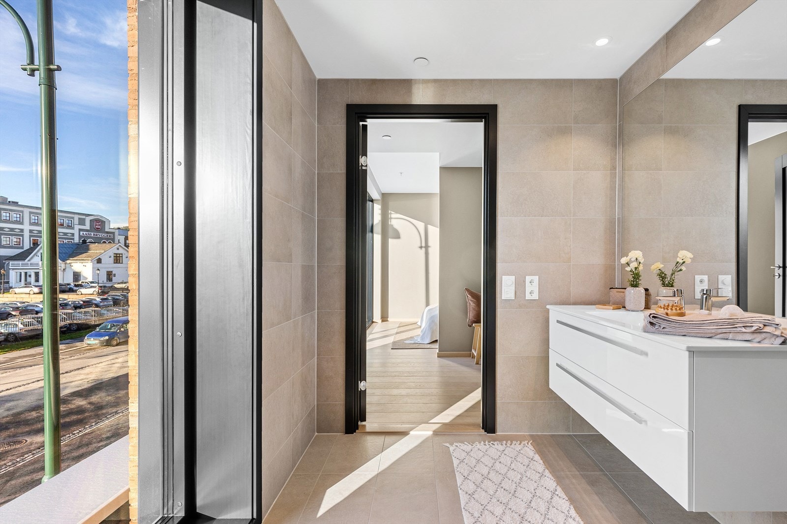 Badet er lyst og delikat med vegghengt baderomsinnredning med nedfelt servant og stort spesialtilpasset speil Galleribilde