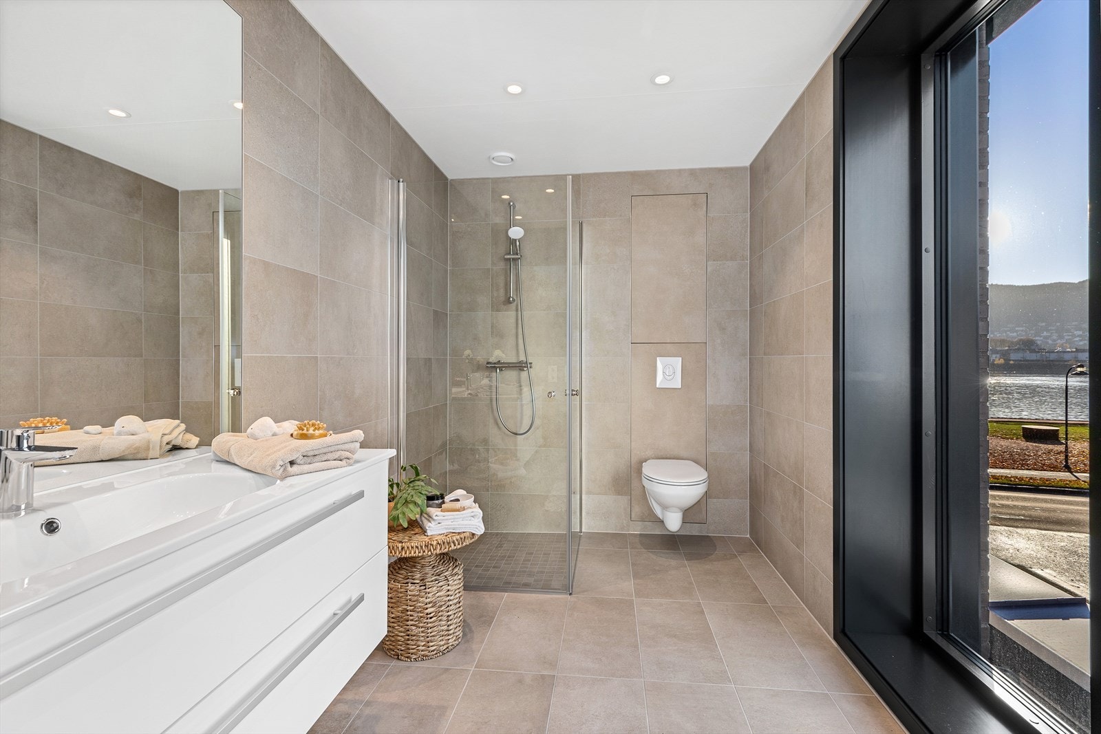 Videre er det dusj med innfellbare dusjvegger og vegghengt toalett Galleribilde