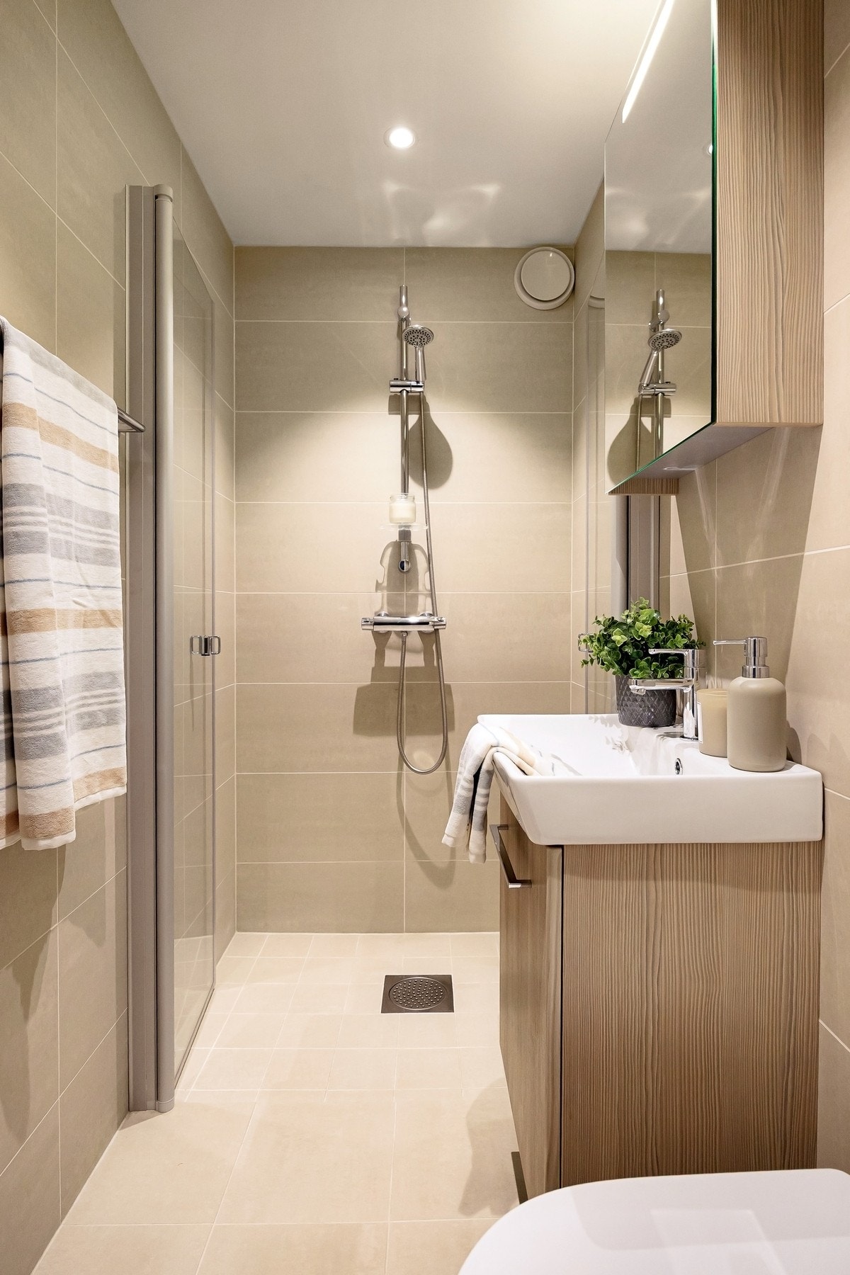 Bad (2). Utstyrt med servantinnredning, vegghengt toalett og dusj med glassdør. Galleribilde