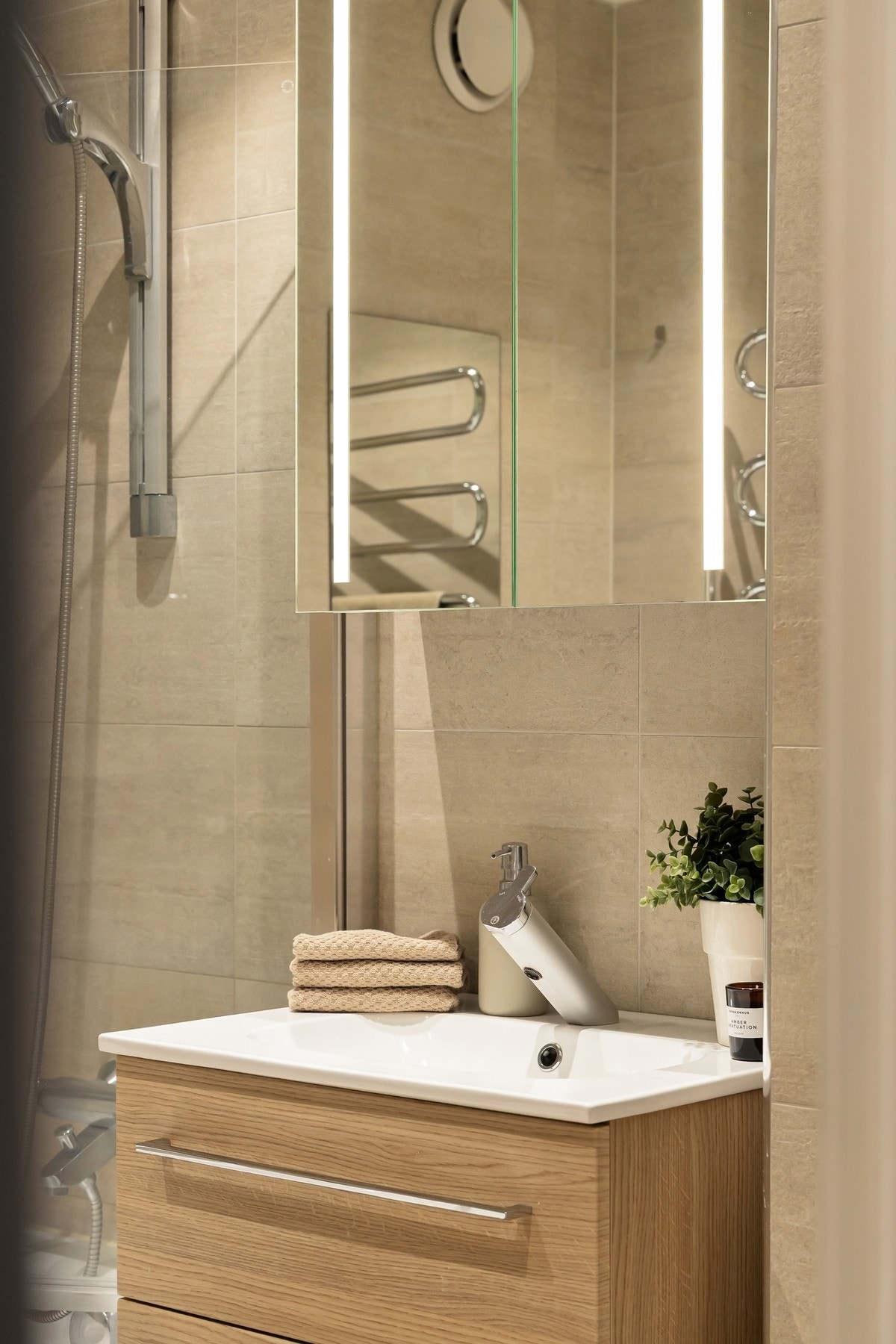 Bad (1). Utstyrt med pen servantinnredning, overskap, veggskap, vegghengt toalett og badekar med dusjvegg i glass. Det er varme i gulvet. Galleribilde