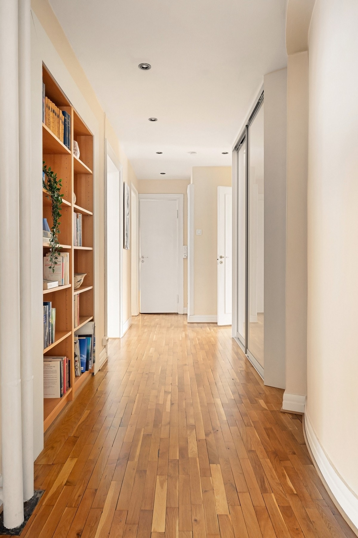 Mellomgang med integrert skyvedørsløsning og bokhyller som gir godt med oppbevaringsplass Galleribilde