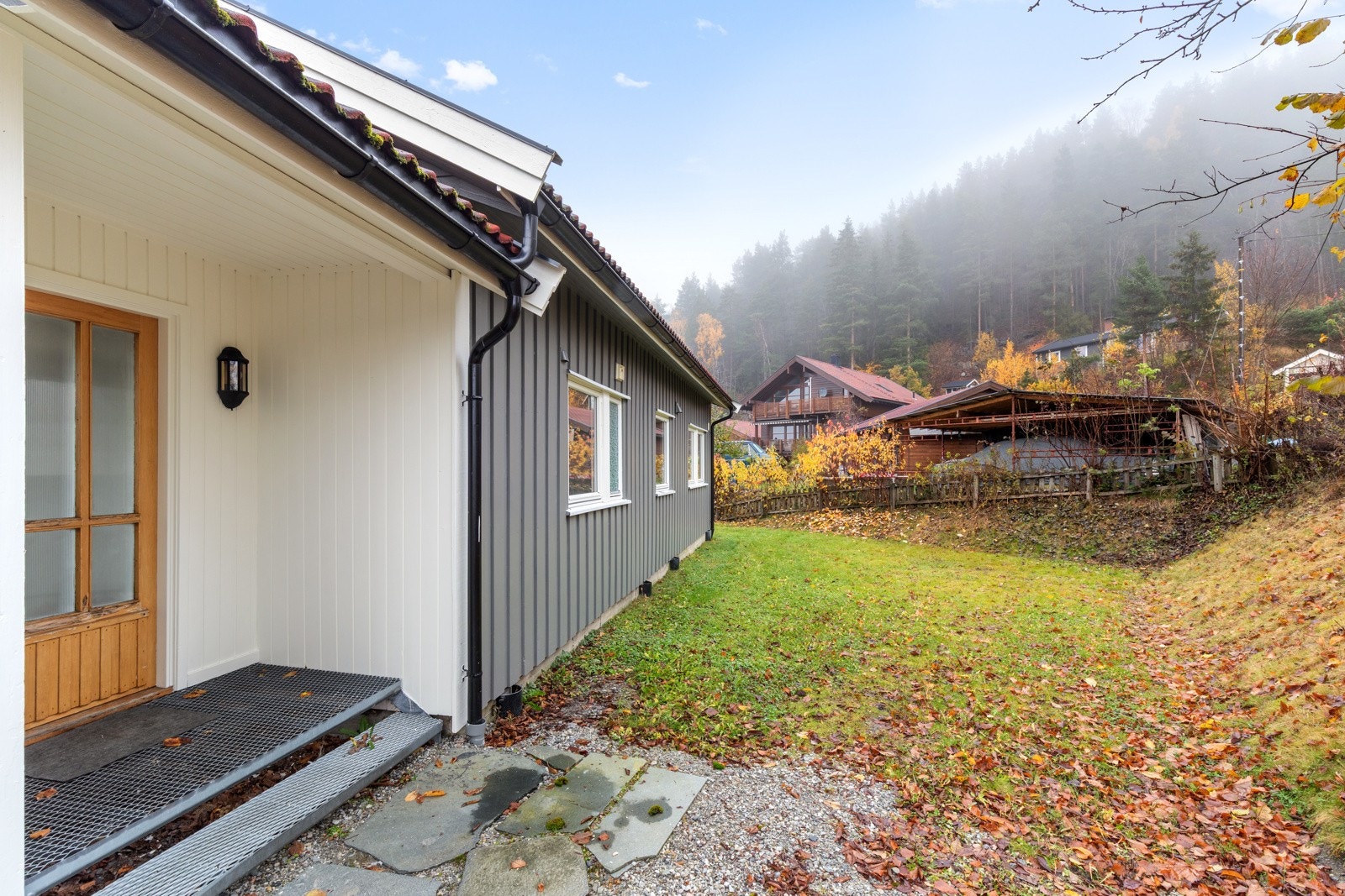 Koselig inngangsparti bak boligen. Her har man tilgang til plen og hage. Galleribilde