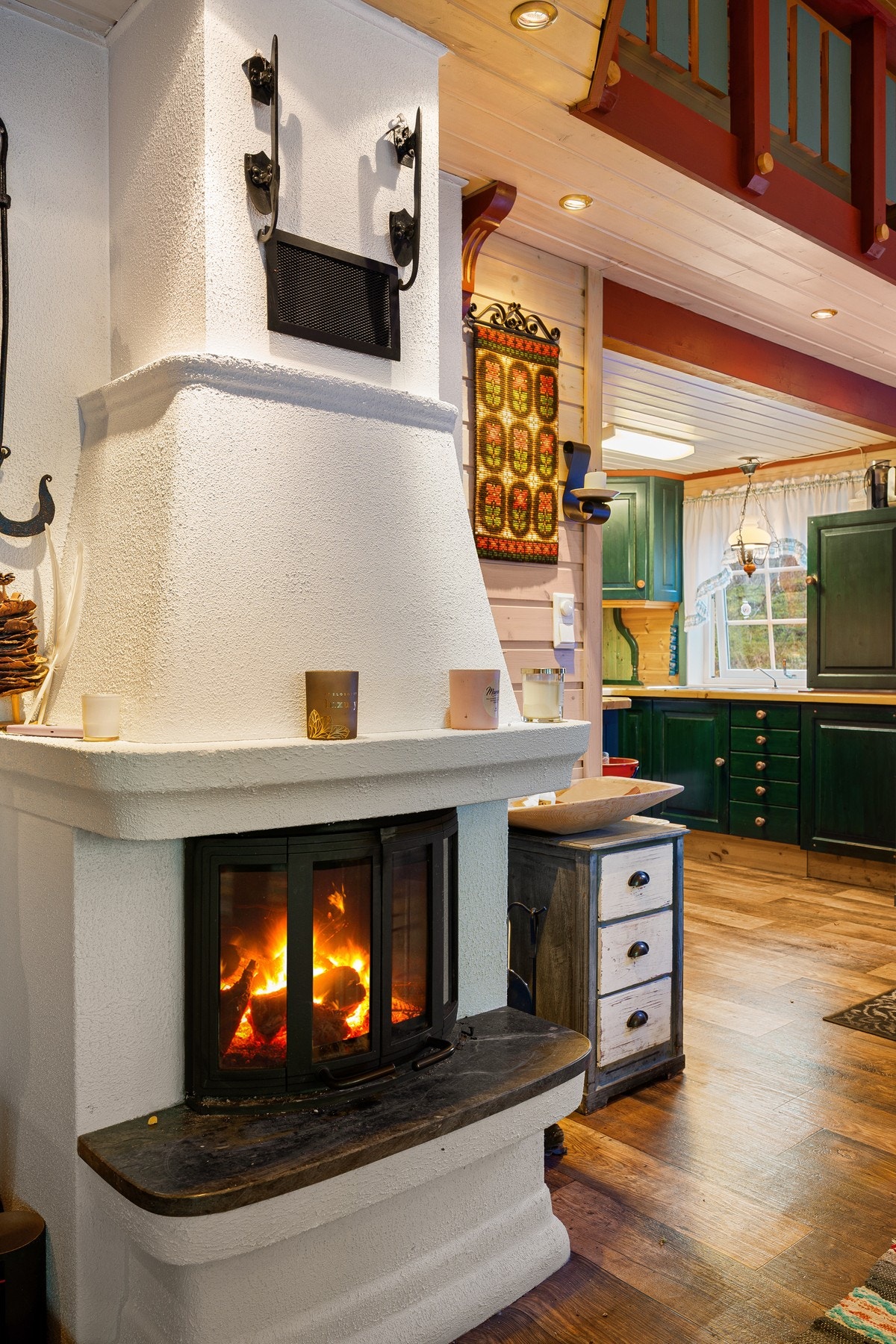 Stuen har peis, som sammen med elektrisk oppvarming sørger for behagelig innetemperatur gjennom hele året Galleribilde