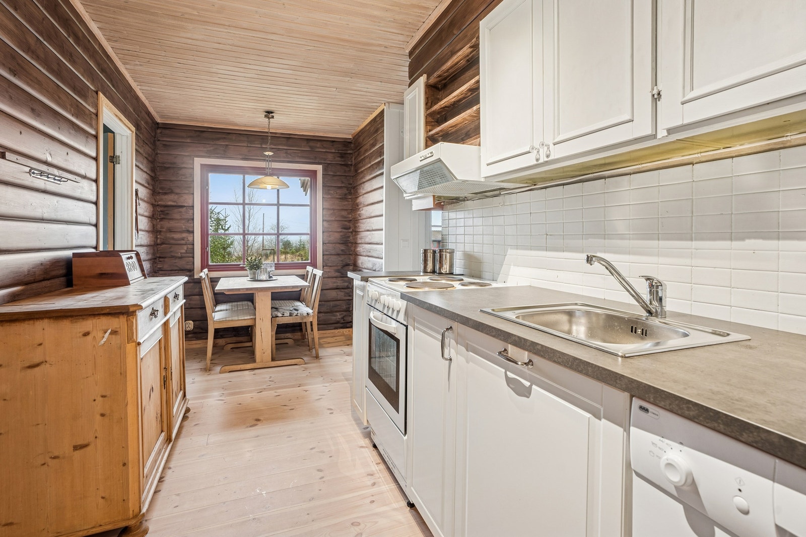 Innredningen har profilerte fronter, laminatbenkeplate og integrert oppvaskmaskin. Galleribilde