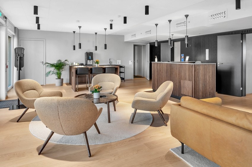 Servicesenter med sittegrupper, kaffemaskin, peis, bibliotek, magasiner og aviser. Galleribilde