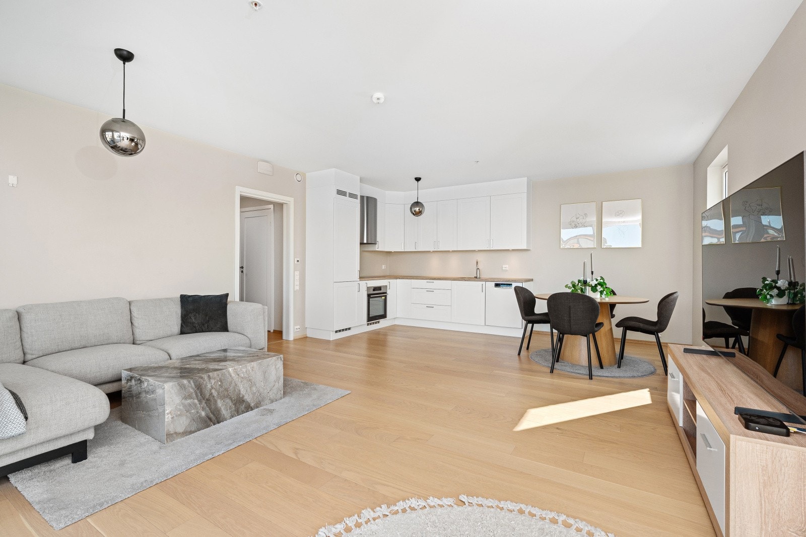 Stuen er malt i en llun farge som skaper en fin atmosfære i rommet. Den åpne stue/kjøkken løsningen gjør at man kan være sosial under kokkeleringen mens gjestene venter. Galleribilde