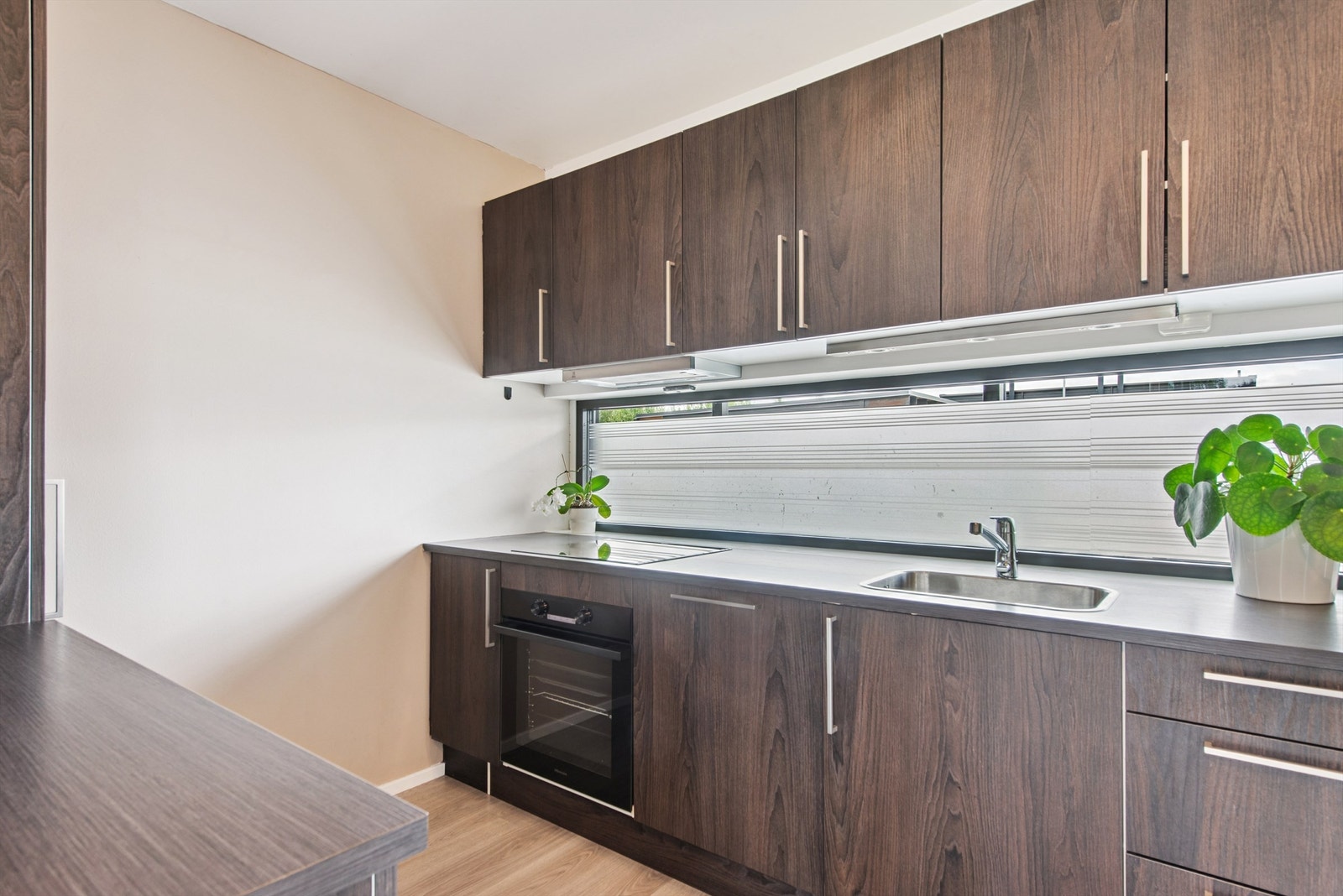 Innredningen har folierte fronter, laminatbenkeplate og integrerte hvitevarer, inkludert ny stekeovn fra 2025. Galleribilde