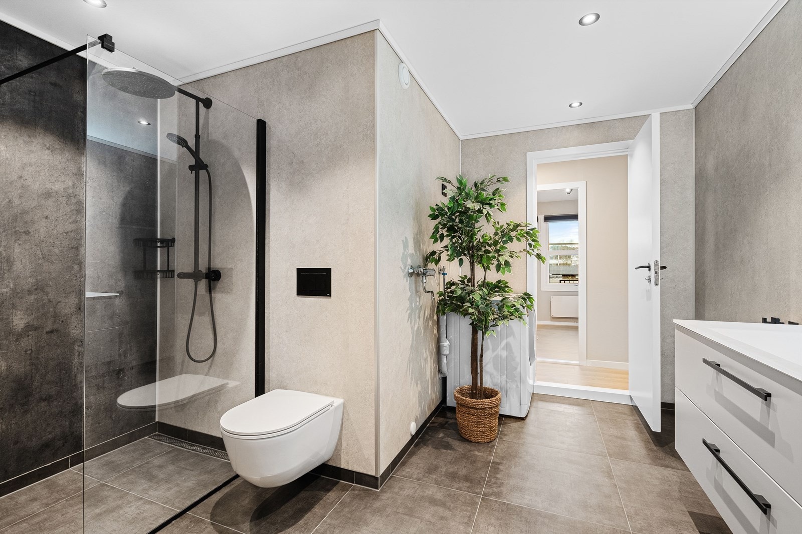 Badet består av fliser på gulv m/varmekabler og våtromsplater på vegg. Galleribilde