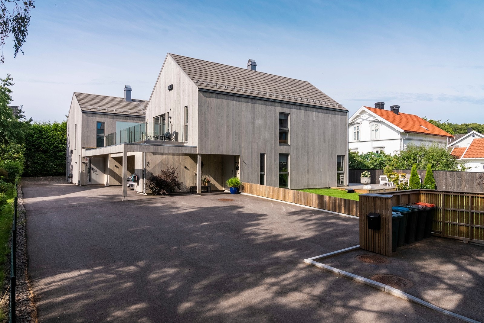 Ved carporten har boligen en isolert bod fra 2022, og foran inngangen er det mulighet for ytterligere parkering på en asfaltert gårdsplass. Galleribilde