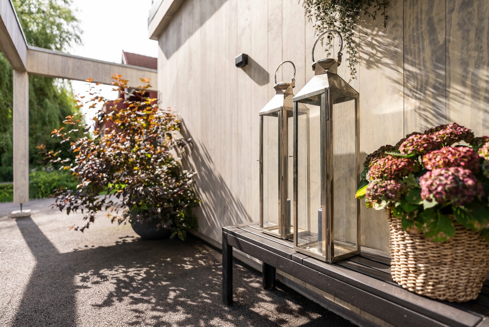 Et overbygd inngangsparti ønsker velkommen, med belysning, elektronisk lås og god plass til en benk eller et kafésett. Galleribilde