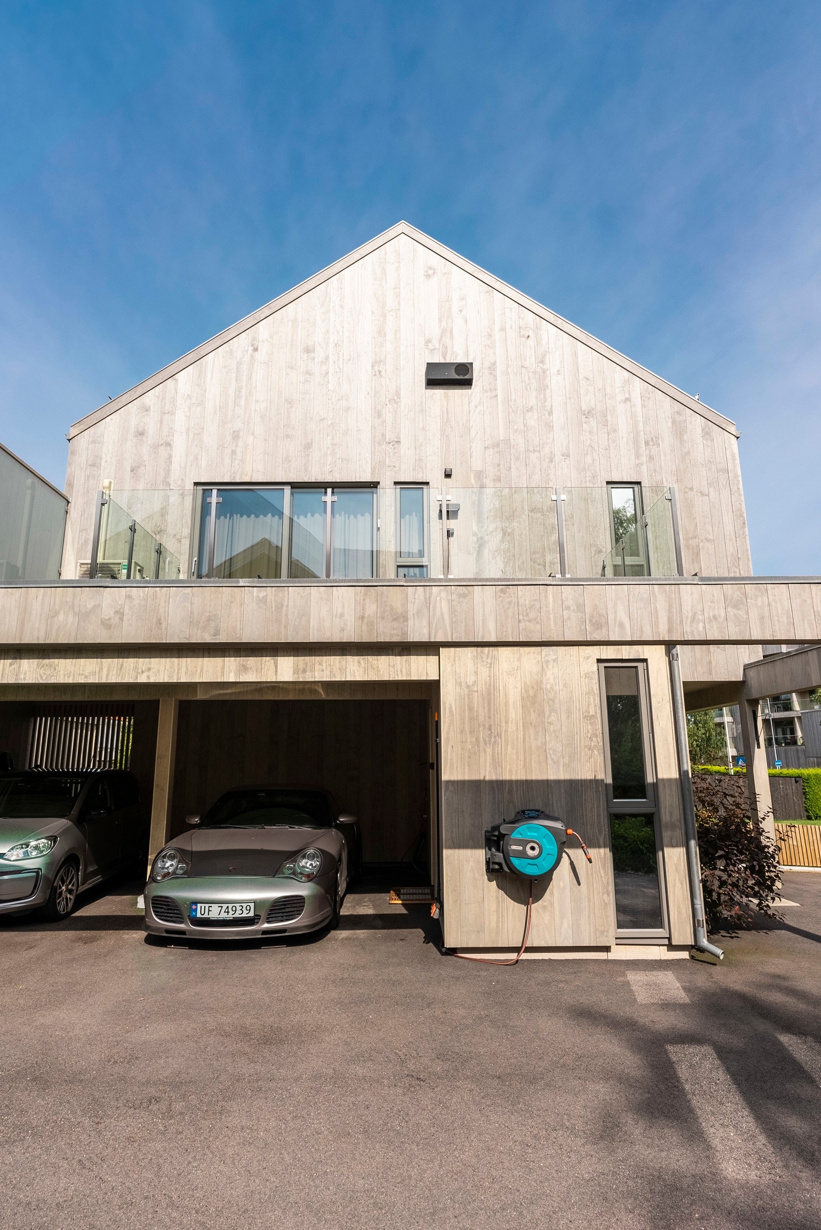 Det er parkering i en asfaltert carport ved inngangen, og carporten er klargjort for montering av elbillader. Galleribilde