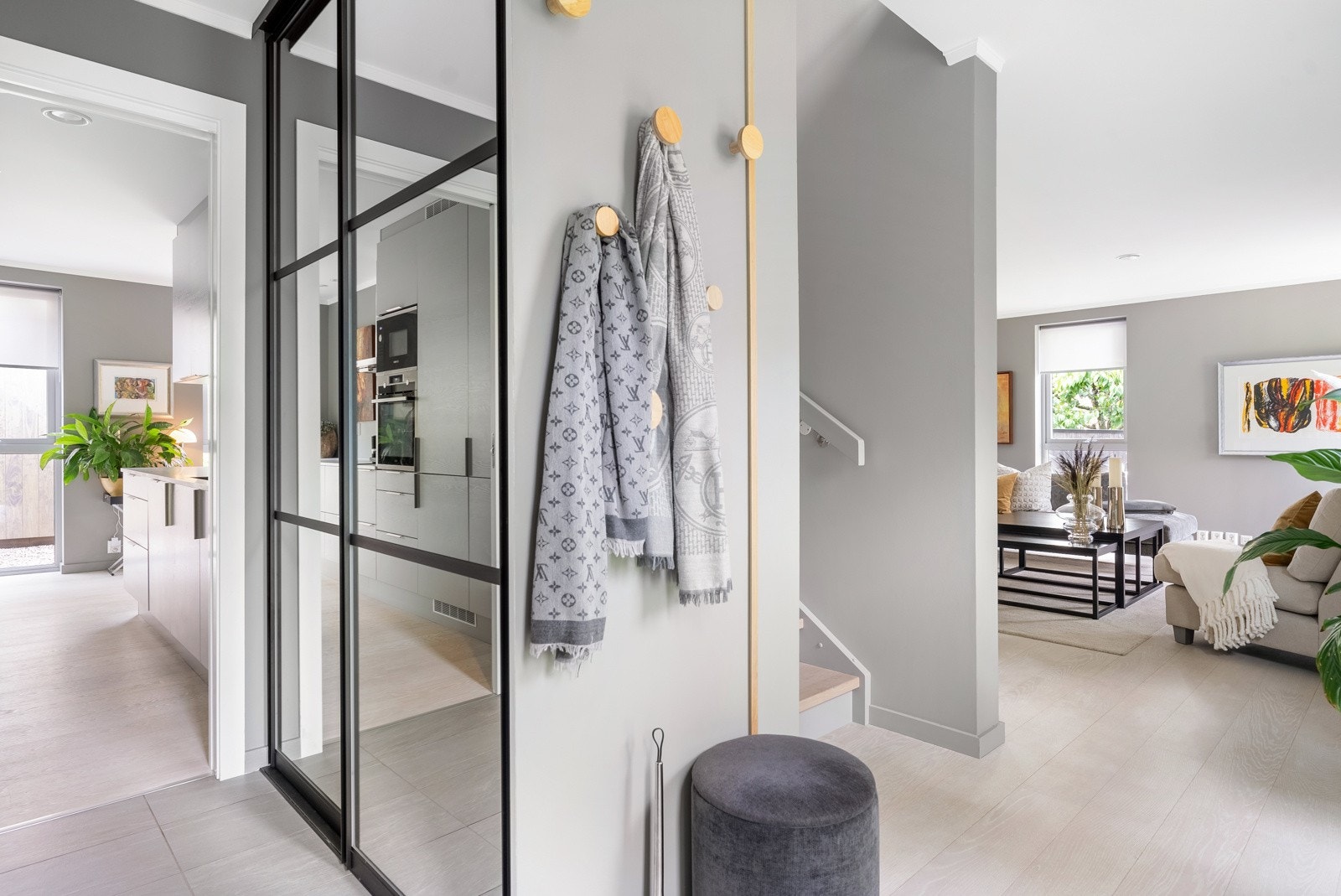 Yttertøyet ryddes enkelt bort i en stor og plassbygd skyvedørsgarderobe med speilfronter og sort innramming. Galleribilde