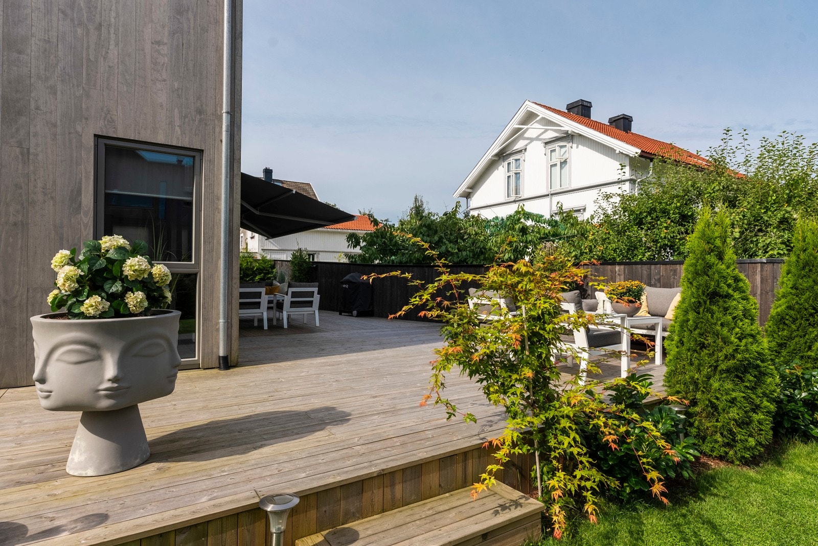 Belysning og utestikk er montert, og et fint bed i front bidrar til å skape et noe skjermet uterom. Galleribilde