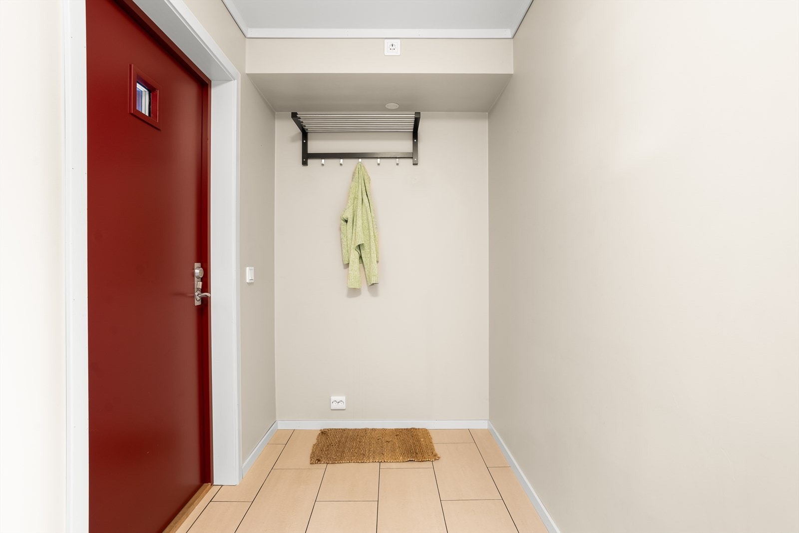 Lys og romslig entré med plass til oppheng av yttertøy og til å sette fra seg sko. Galleribilde