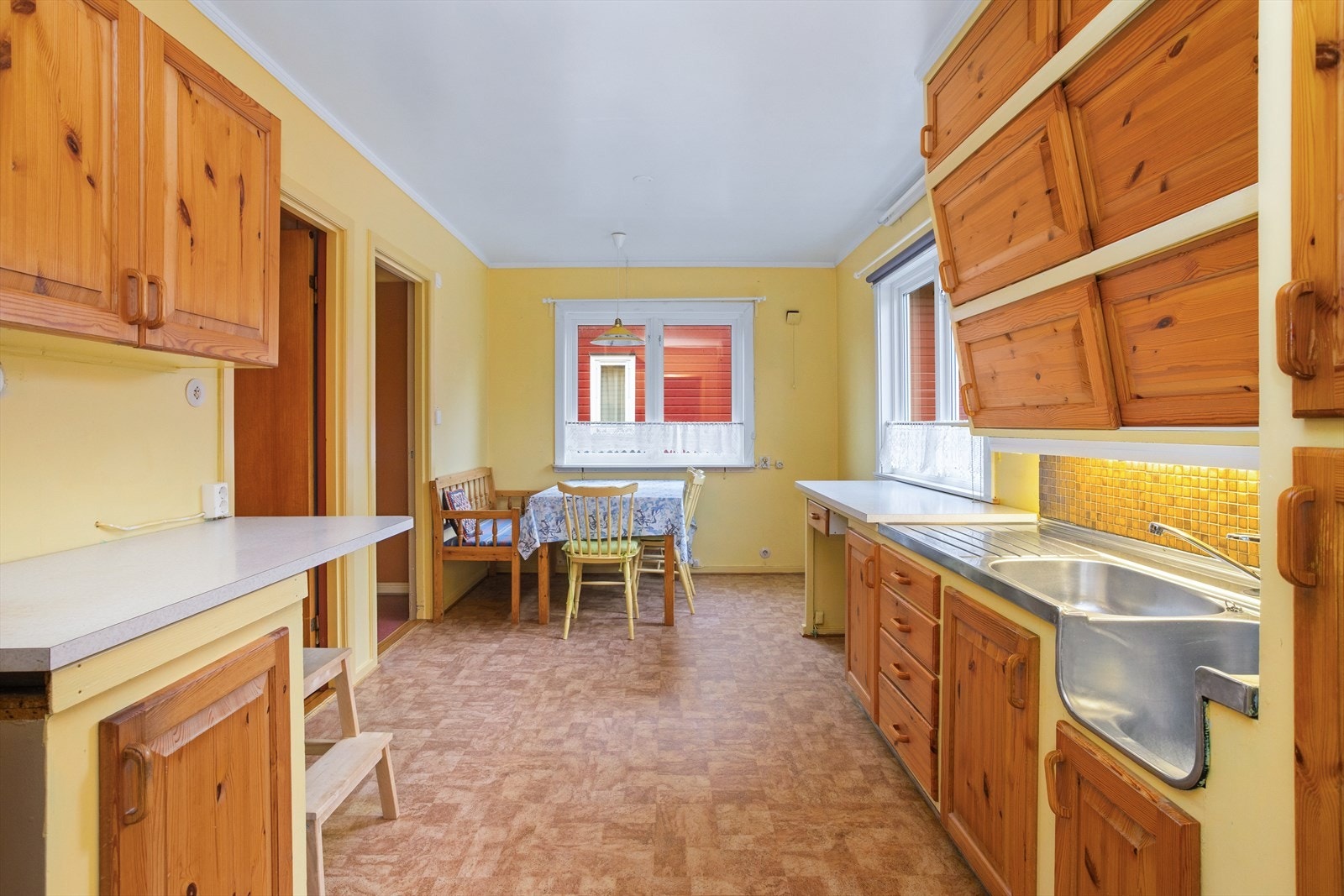 Innerst i rommet er det en hyggelig sone for spise-/anretningsbor. Innredningen er klassisk med både over-/underskap som blant annet også inkluderer skuffeseksjoner og et innslag av overskap med skyvedørsfronter. Galleribilde