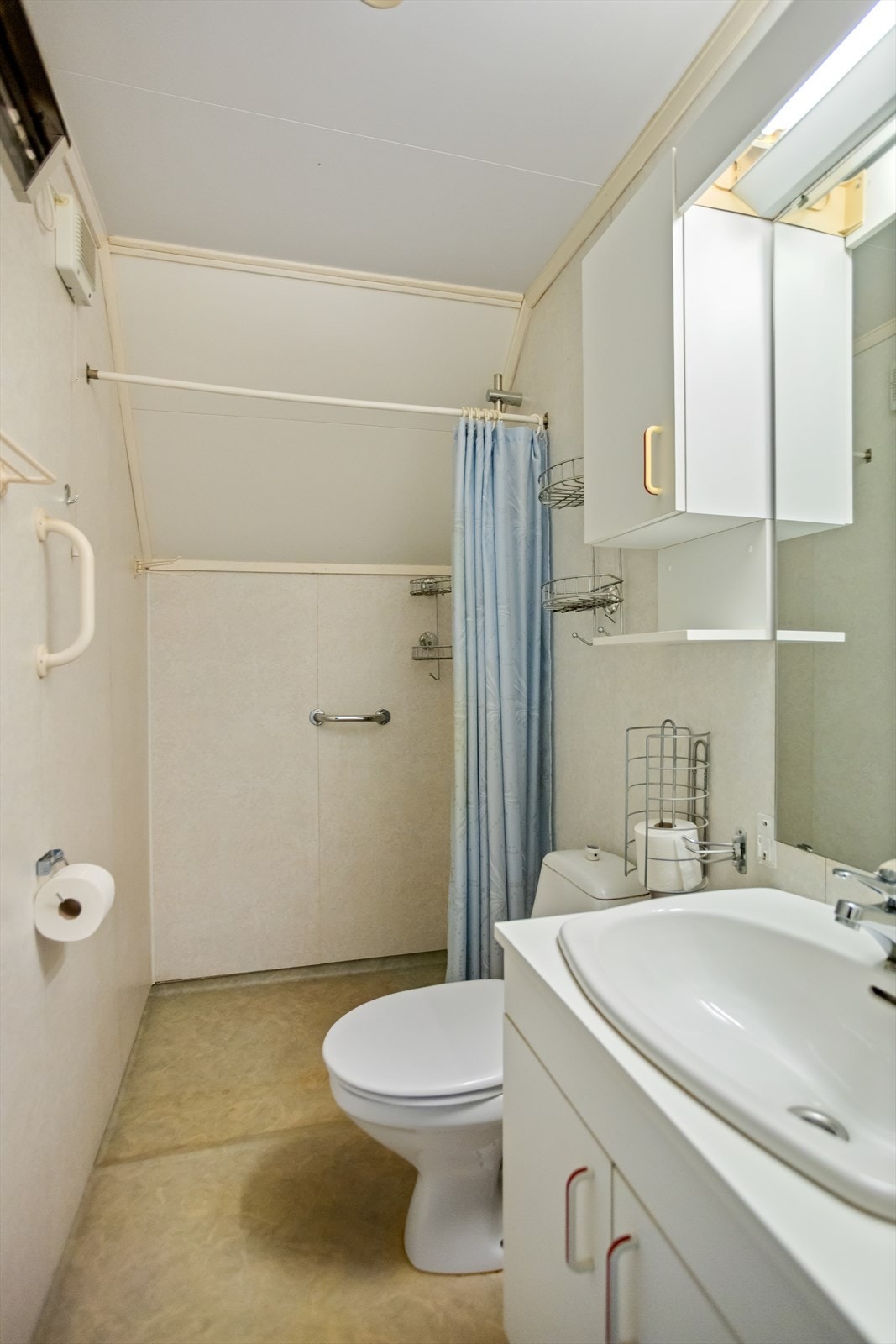 Baderommet er noe oppusset/rehabilitert i 1995 og tilbyr dusjnisje med noe nedsenket gulv, sokkeltoalett og baderomsmøbel med underskap, overskap og servant nedfelt i baderombenk. Galleribilde