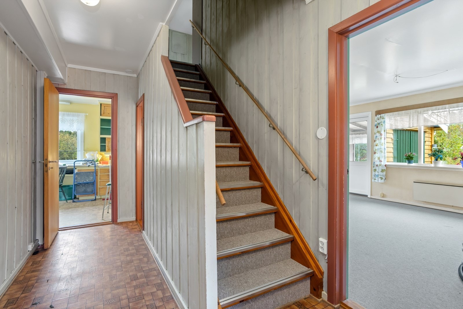 Fra hallen leder den orginale trappen med tette trinn i åpen/eksponert trappegang opp til 2. etasje, innerst i rommet er det lukket trappegang til kjelleretasjen. Galleribilde