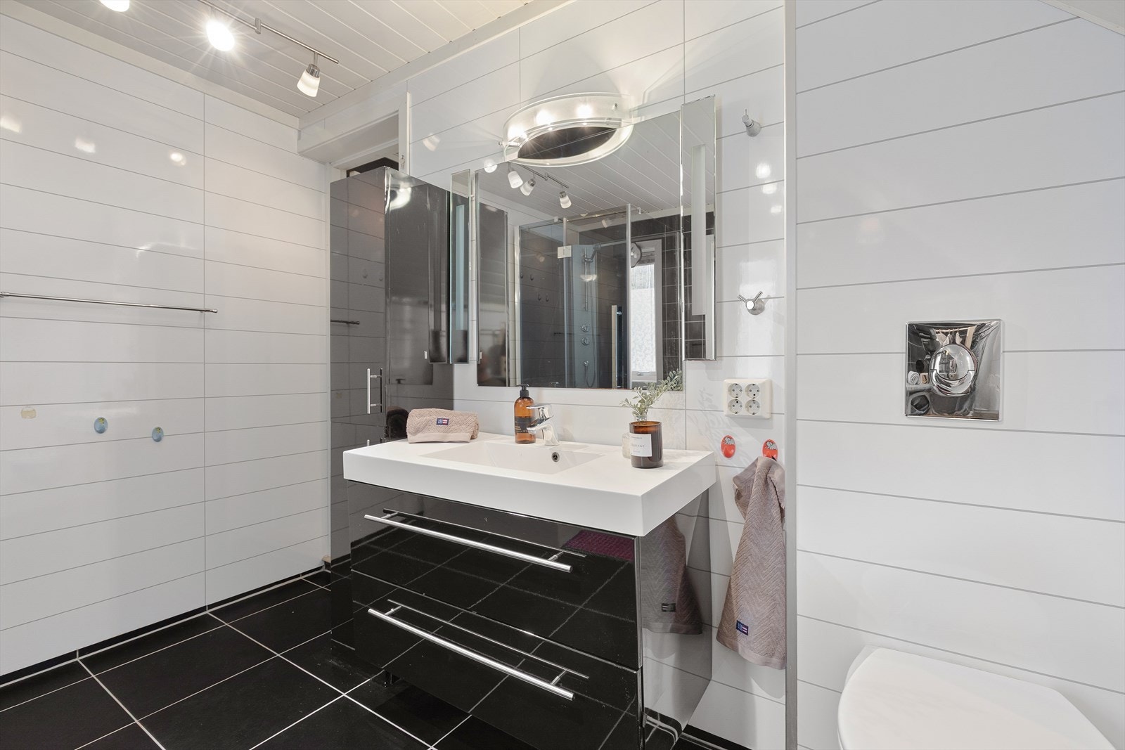 Rommet har innredning med nedfelt servant, veggmontert toalett, dusjkabinett og opplegg for vaskemaskin. Galleribilde