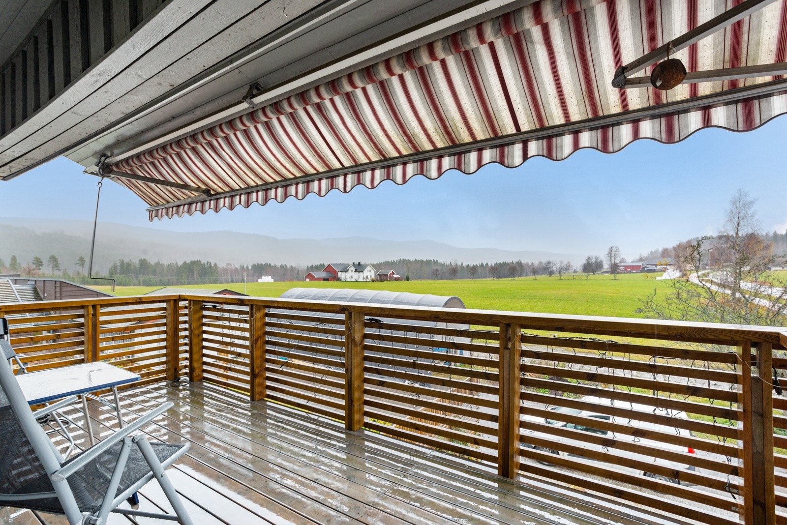 Trivelig balkong utenfor boligdelens 2. etasje, med markise og flott utsyn over nærområdet. Galleribilde