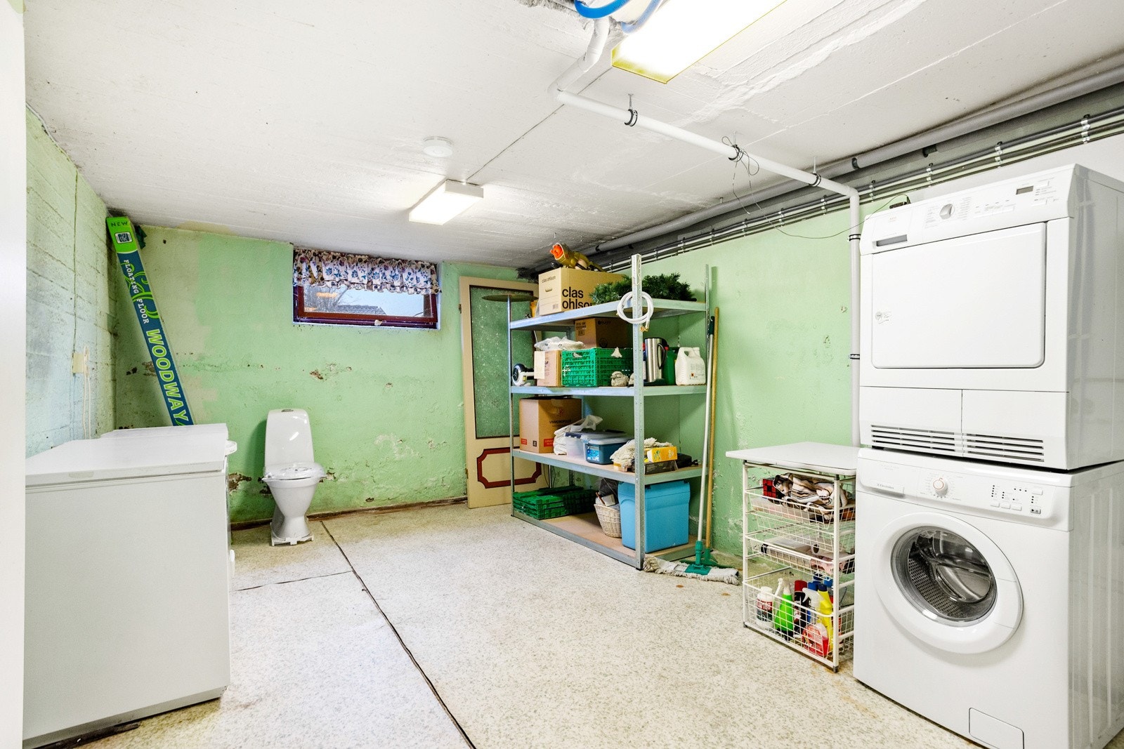 Vaskekjeller med toalett, servant og opplegg for vaskemaskin. Galleribilde